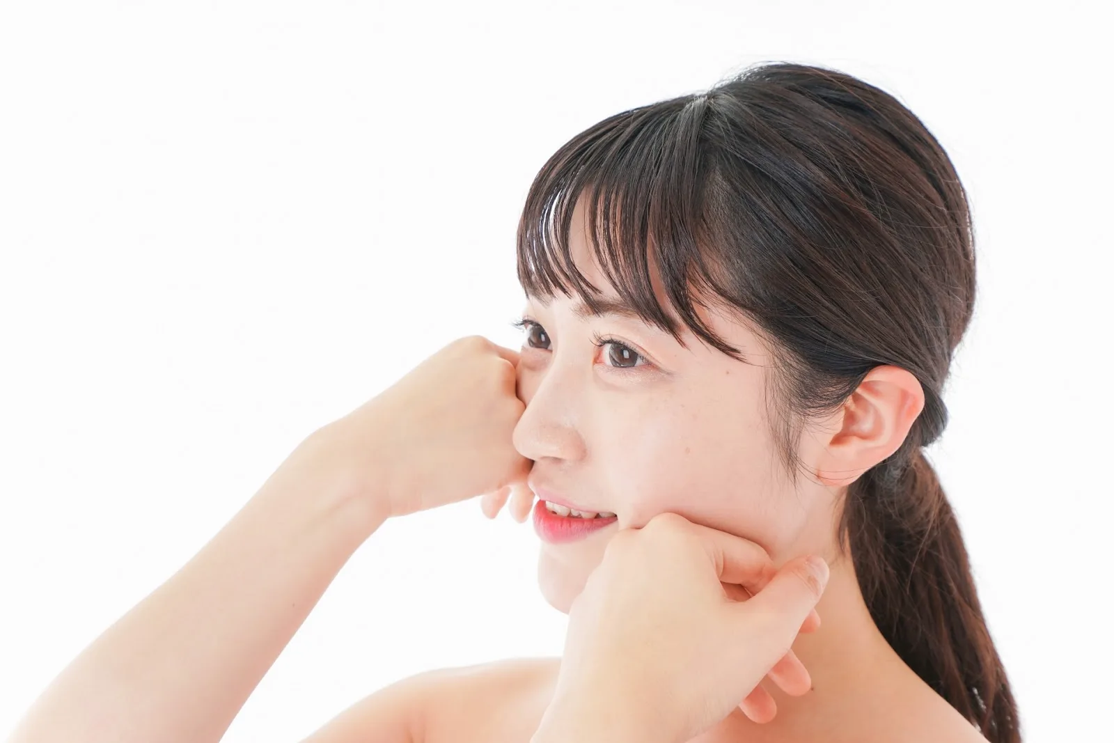 両手で頬に触れる女性の横顔
