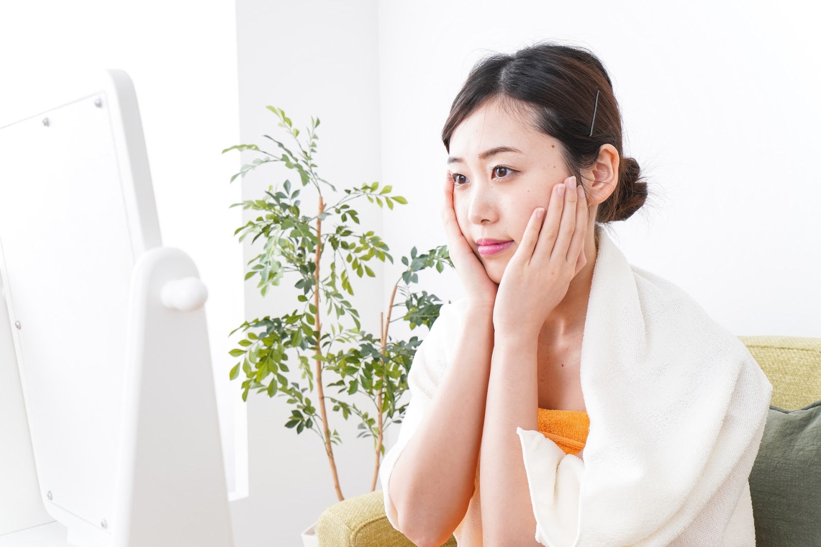 洗顔後に鏡の前で肌を気にする女性