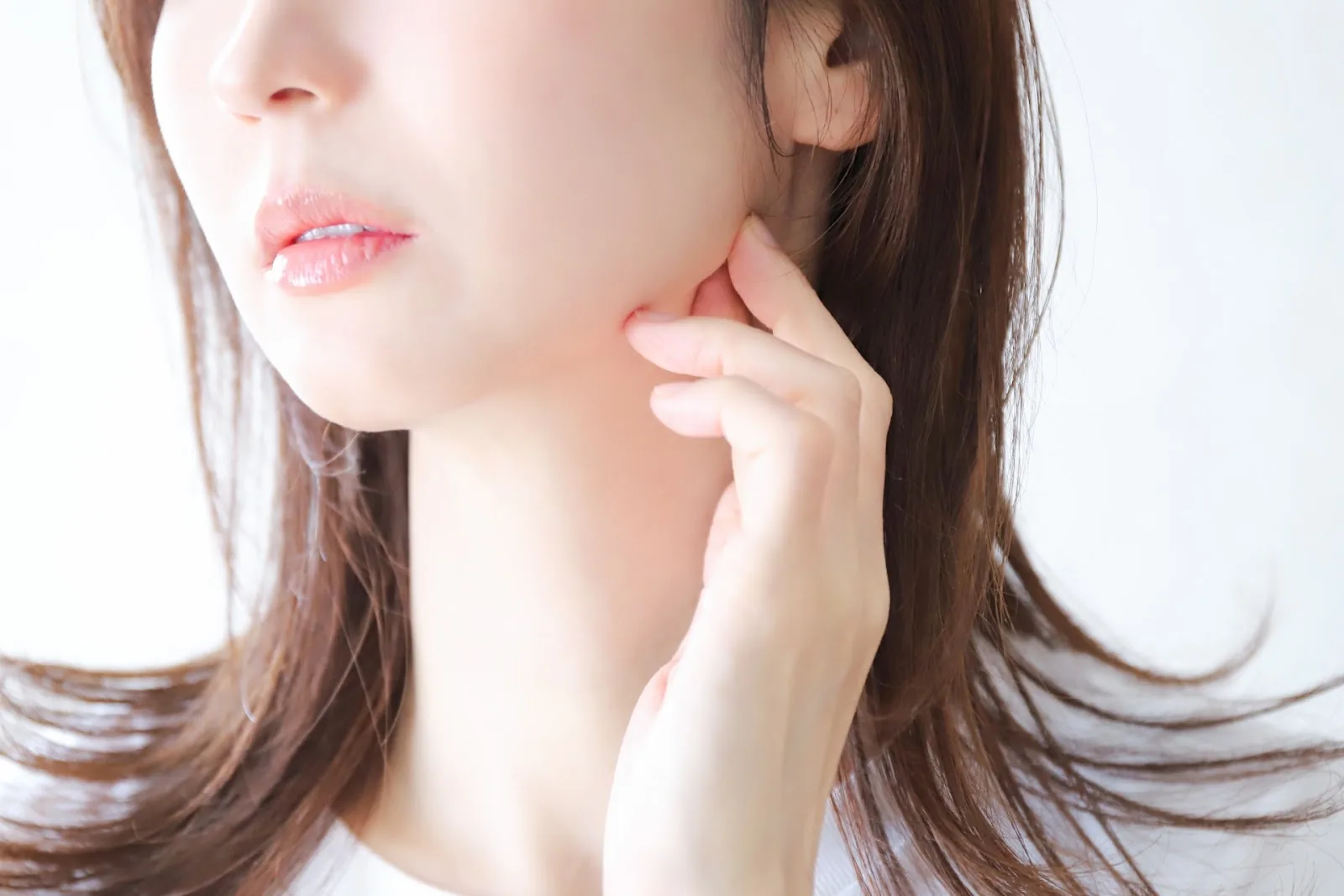 頬を指でおさえる女性