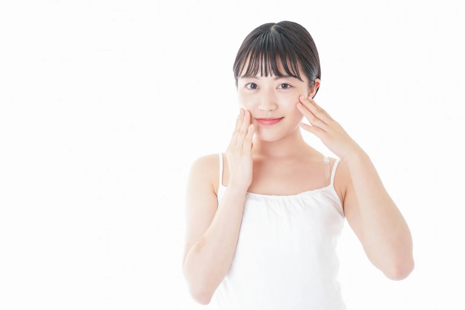 両手で頬に触れる女性