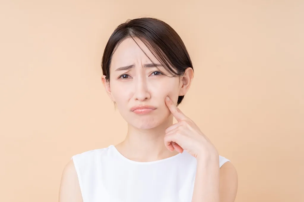 頬に指を当てて困った表情の女性