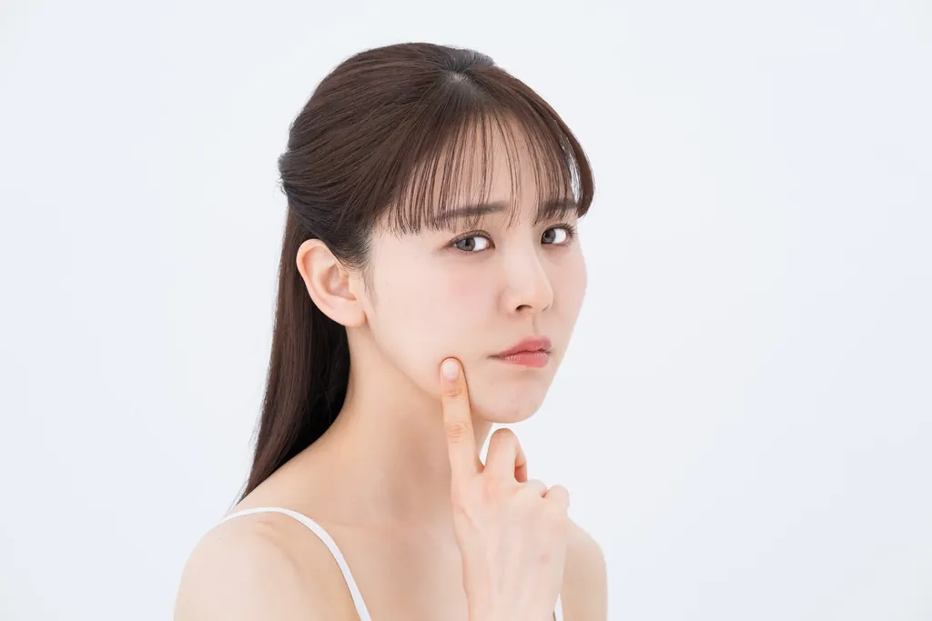 頬に指を当てる女性