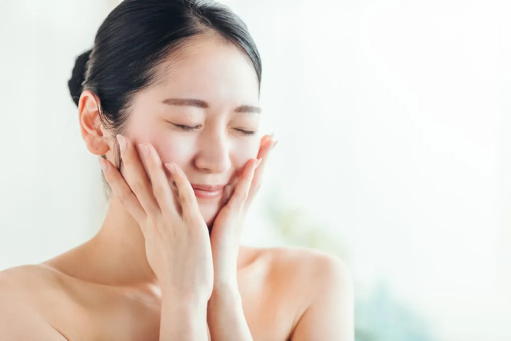 目を閉じて頬に手を添える女性