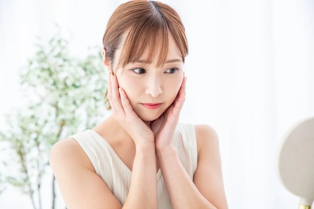 両手で頬を包む女性