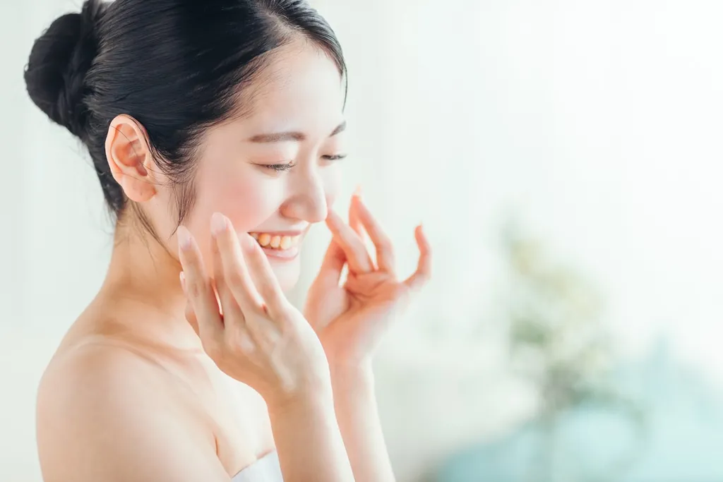 頬に両手を添えてほほえむ女性