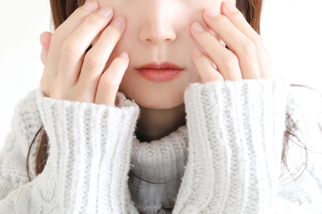 両手で頬を包む女性