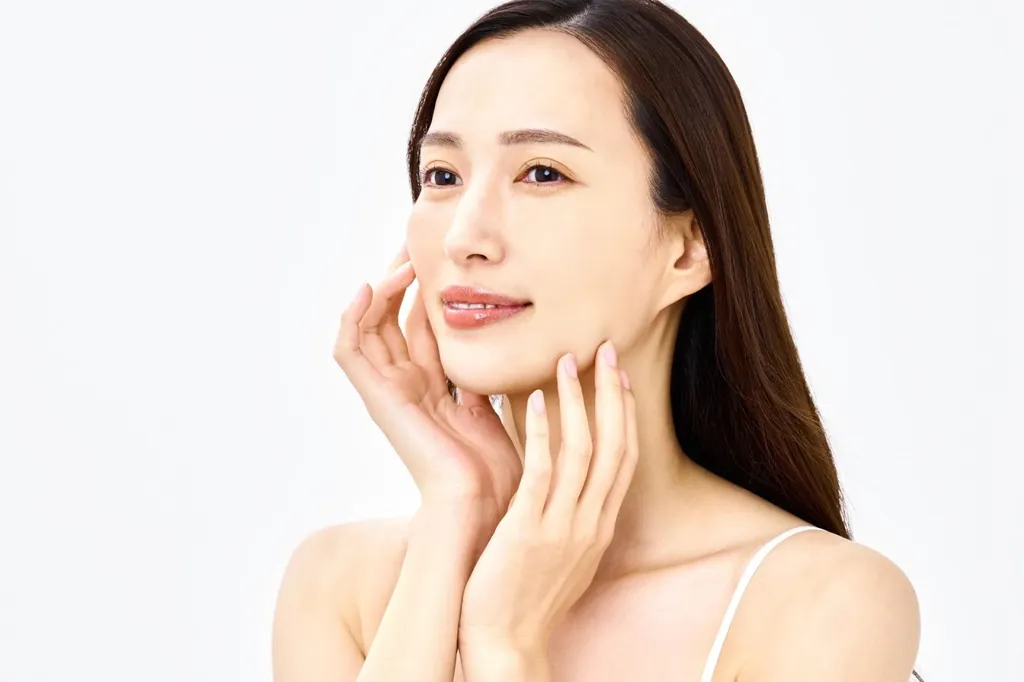 頬に両手を添えてほほえむ女性