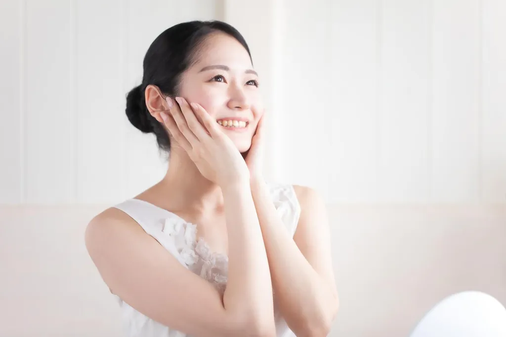 頬に手を添えてほほえむ女性