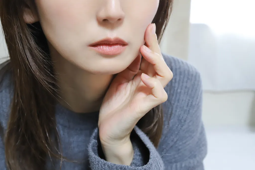 頬に手を添える女性の口元