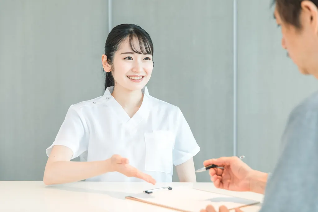 白衣の女性スタッフから説明を受ける様子