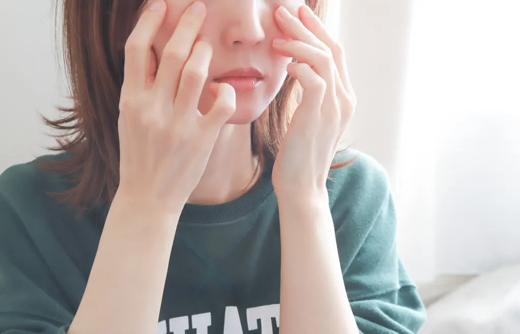 両手で顔を覆う女性
